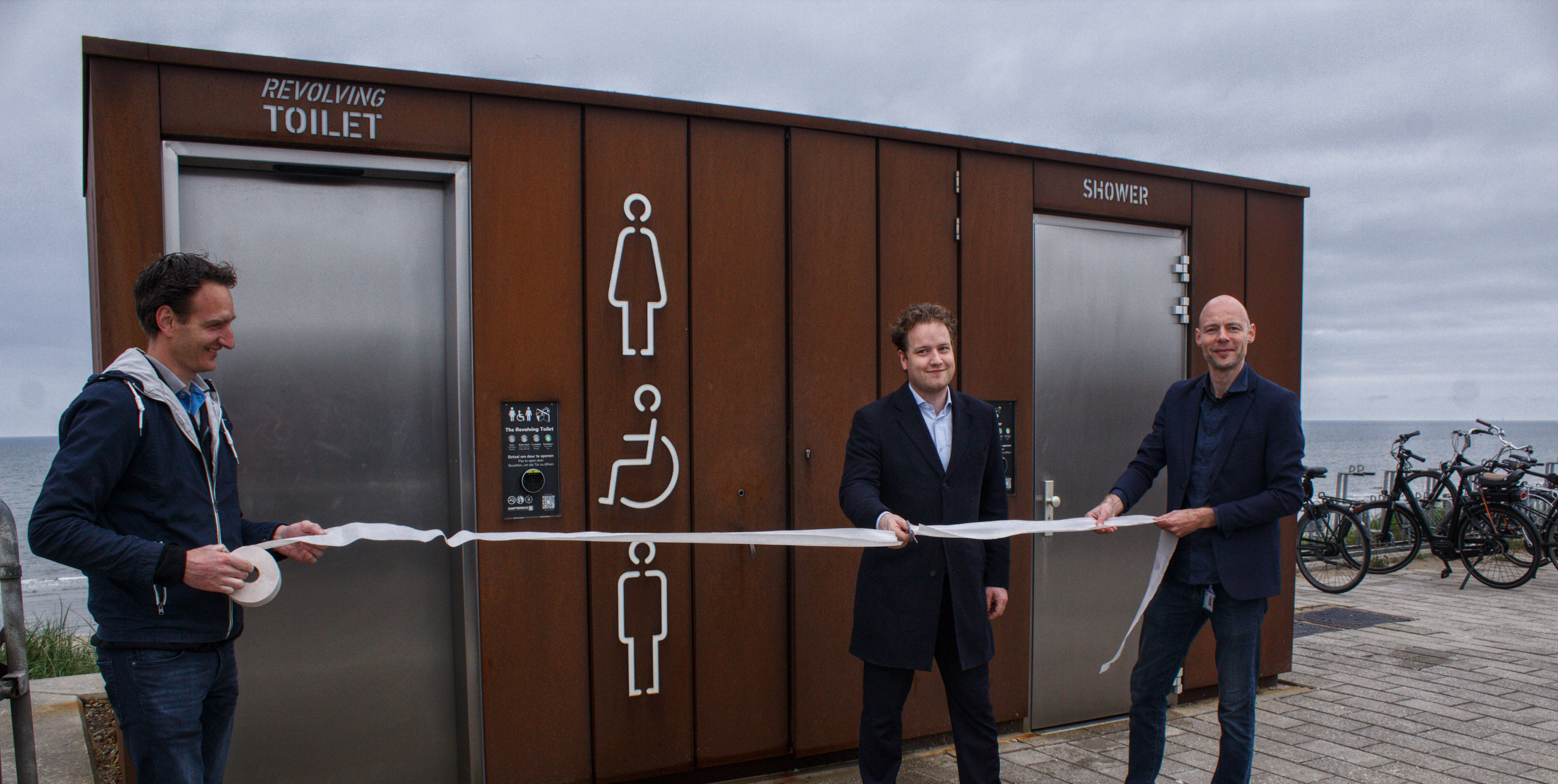 Offizielle Einweihung der rollstuhlgerechten, drehbaren Toilettenanlage mit zwei Urinalen und einer Dusche.
